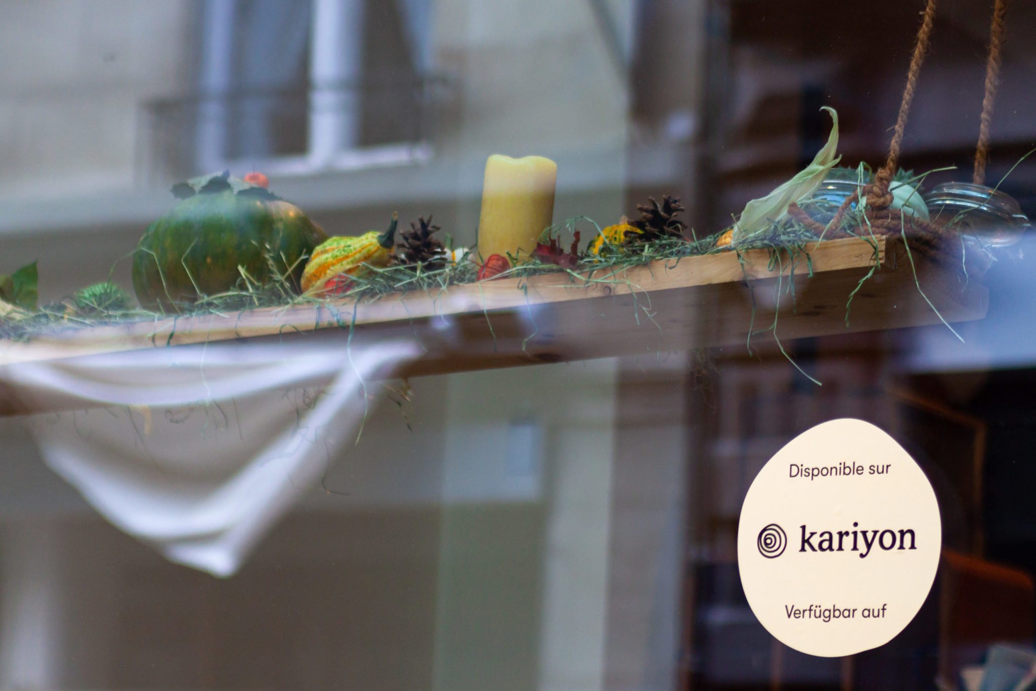 Photo d'un autocollant Kariyon colé sur une vitrine de commerce.